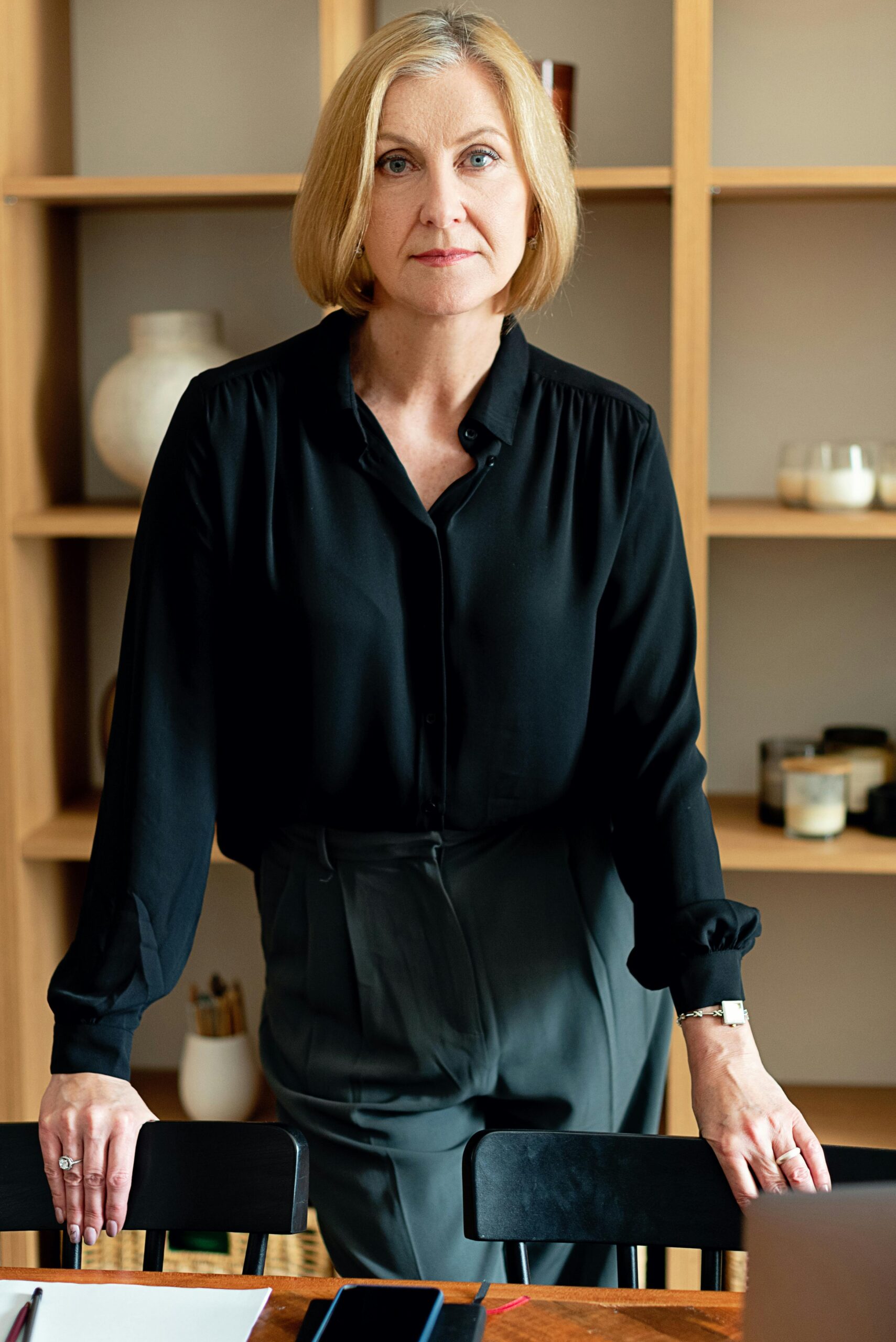 Confident woman standing in a modern office interior, exuding professionalism and leadership.